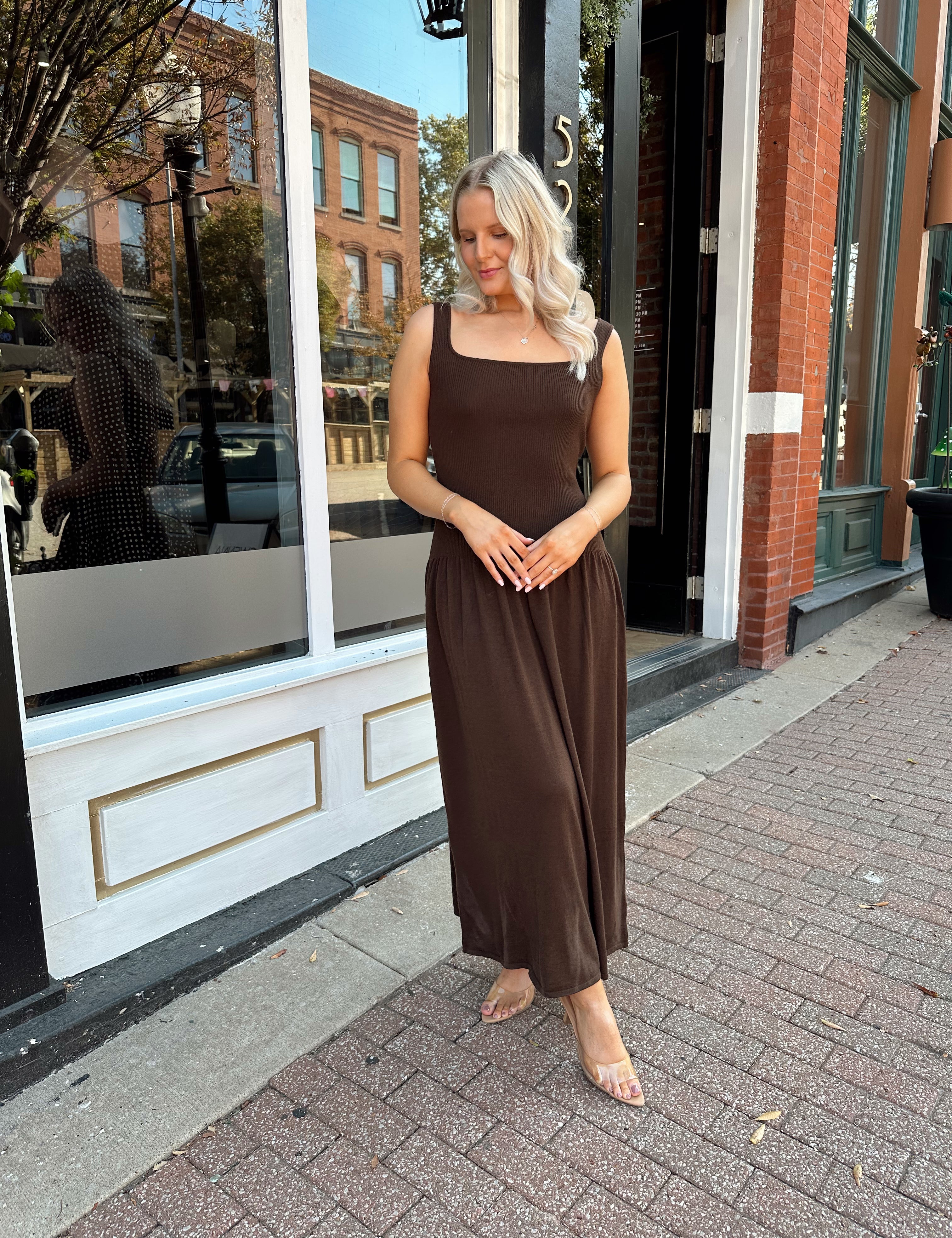Woman wearing brown knit drop waist maxi dress with scoop neckline. 
