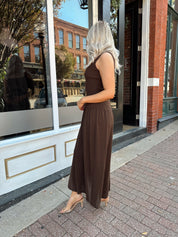 Woman wearing brown knit drop waist maxi dress with scoop neckline. 