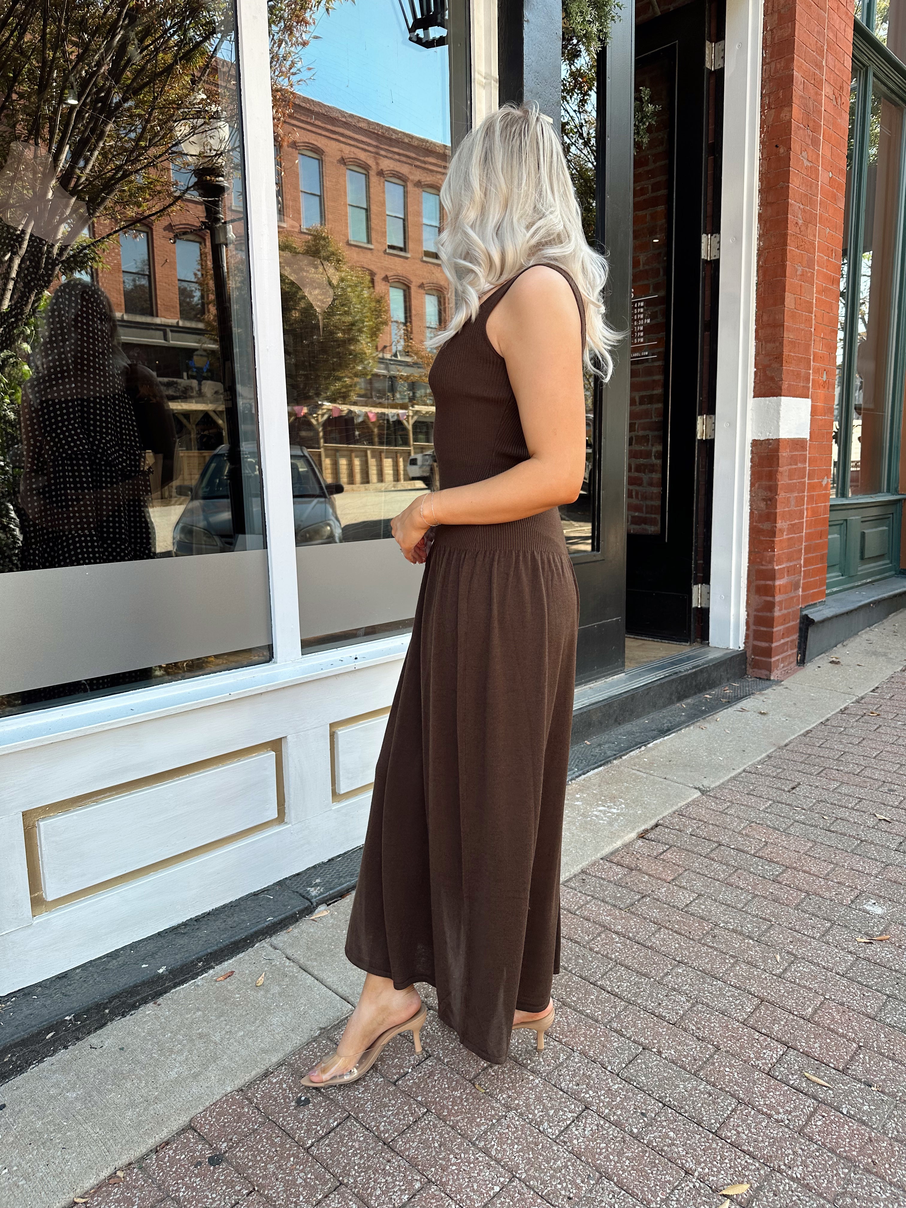 Woman wearing brown knit drop waist maxi dress with scoop neckline. 
