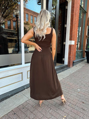Woman wearing brown knit drop waist maxi dress with scoop neckline. 