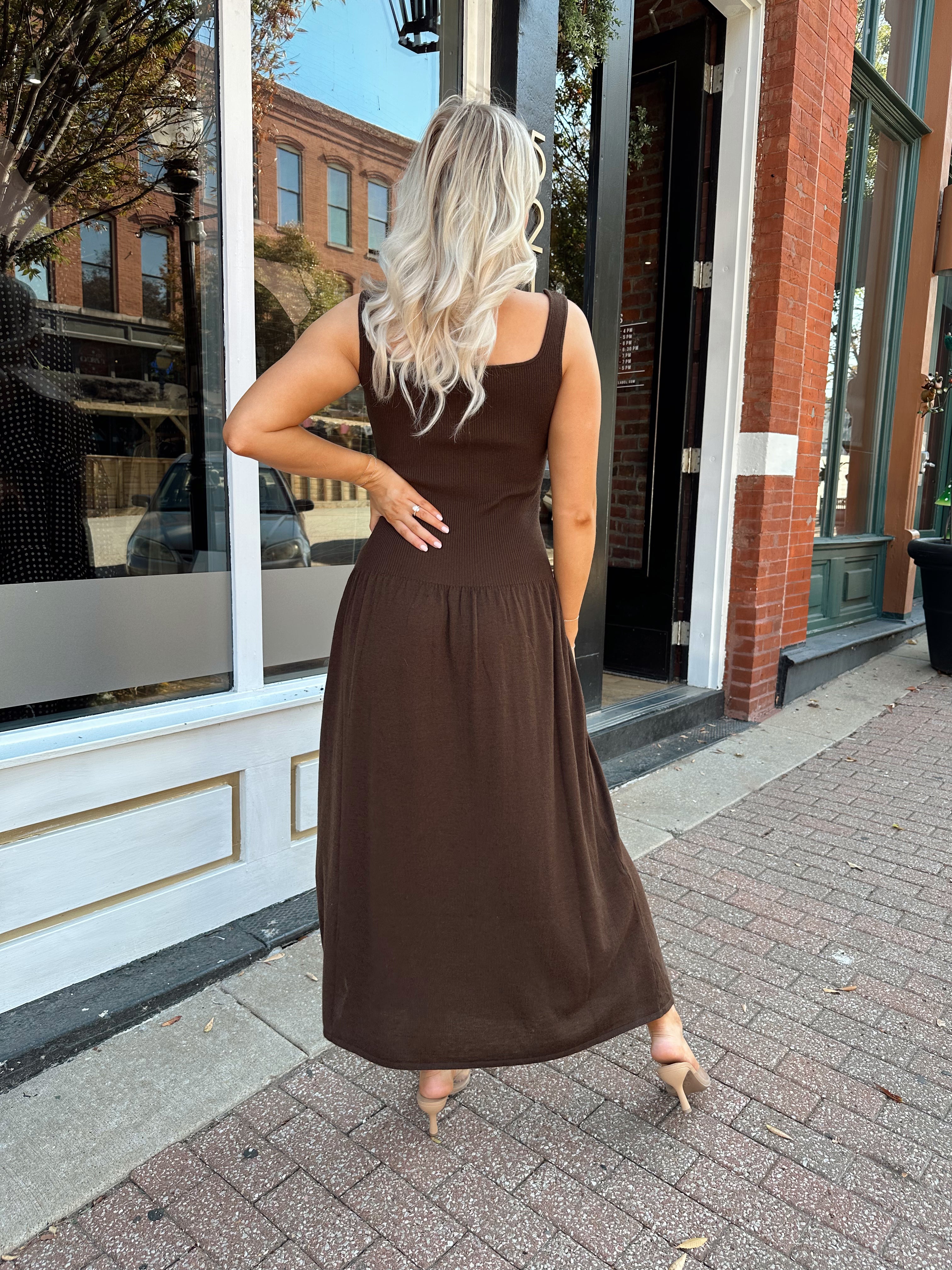 Woman wearing brown knit drop waist maxi dress with scoop neckline. 