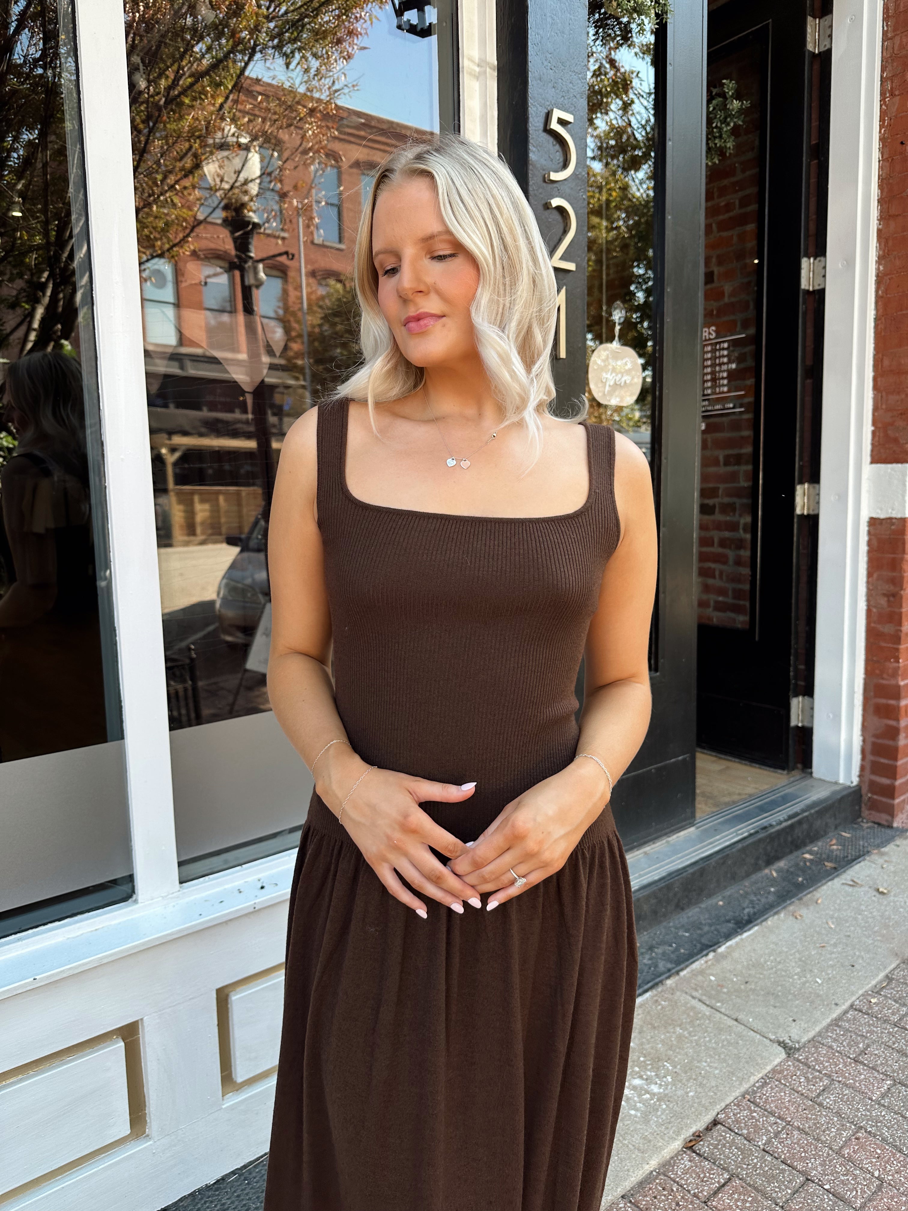 Woman wearing brown knit drop waist maxi dress with scoop neckline. 