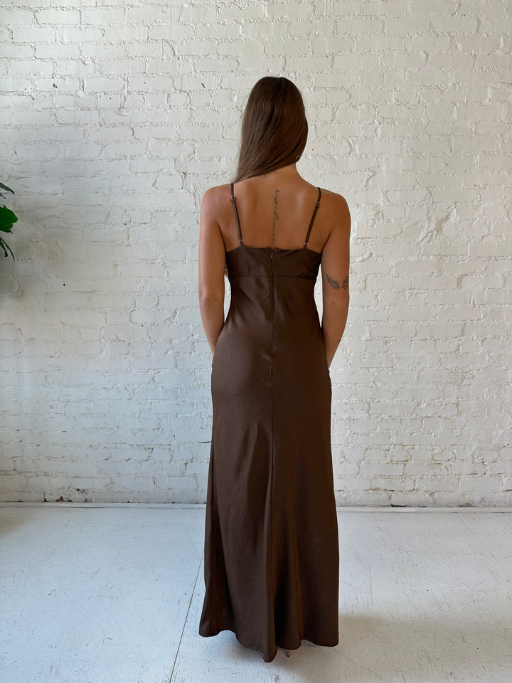 Woman wearing brown textured maxi dress with v-neckline and adjustable spaghetti straps. 
