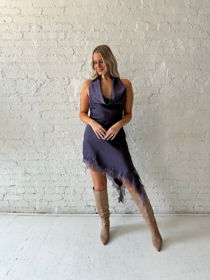 Woman wearing purple satin lace trim midi dress with self tie cowl halter neck. 