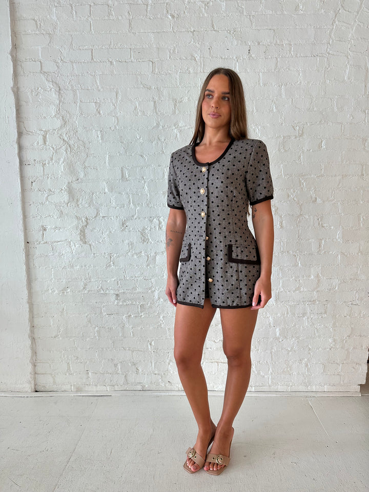Woman wearing mocha textured polka dot two piece tailored set with an kitten heels.
