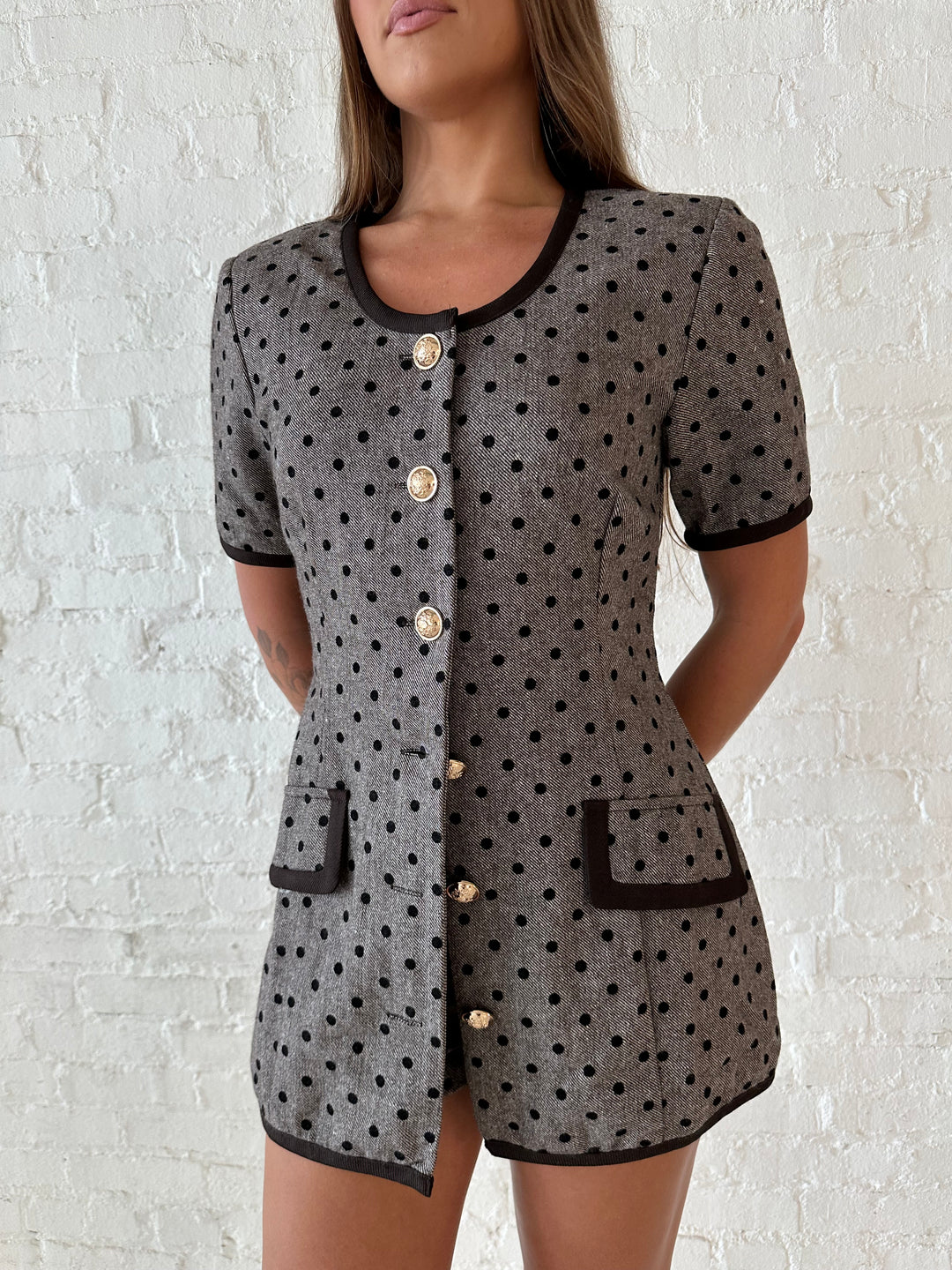 Woman wearing mocha textured polka dot two piece tailored set with an kitten heels.