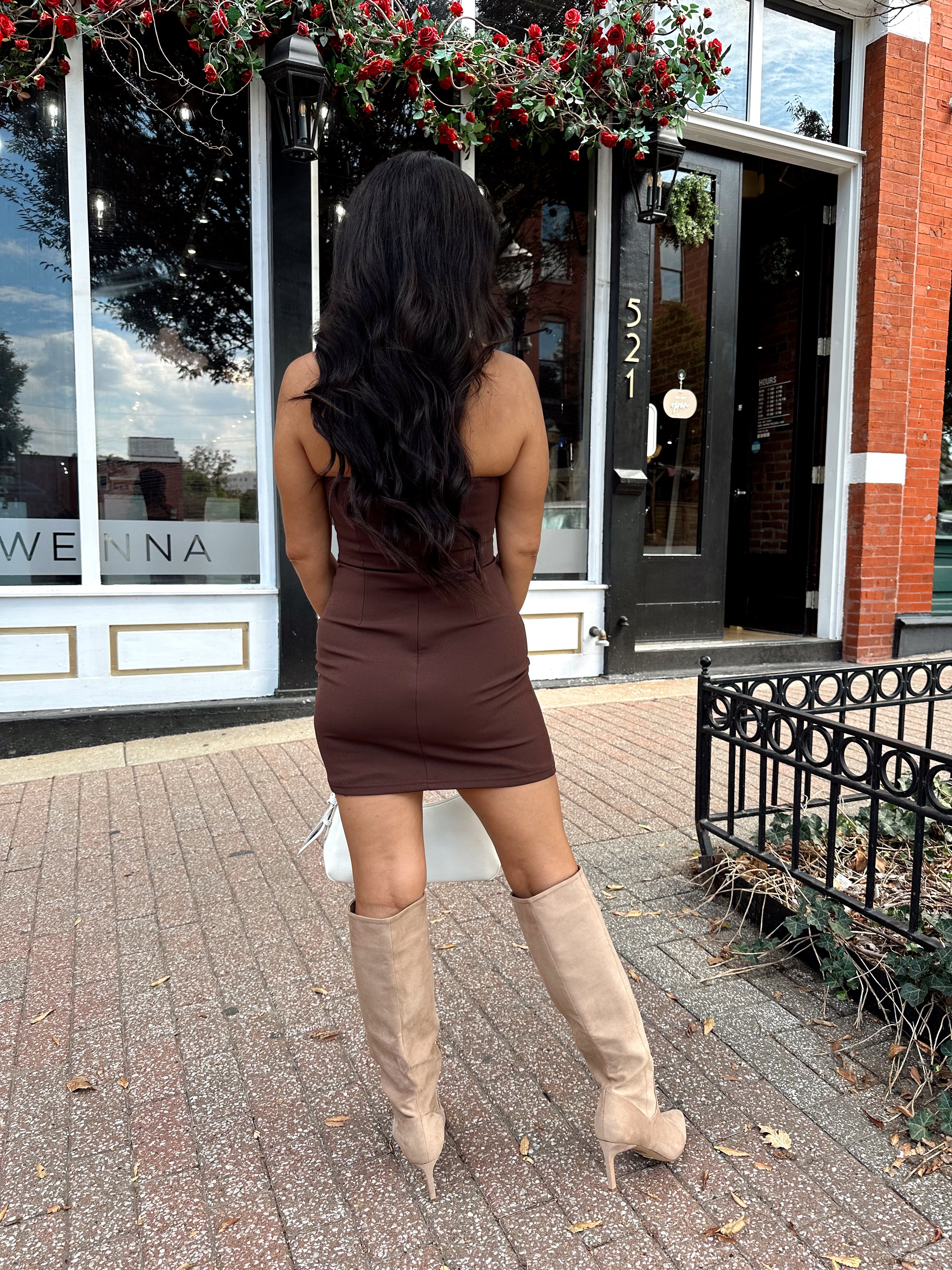 Woman wearing brown mini dress with square neckline. 