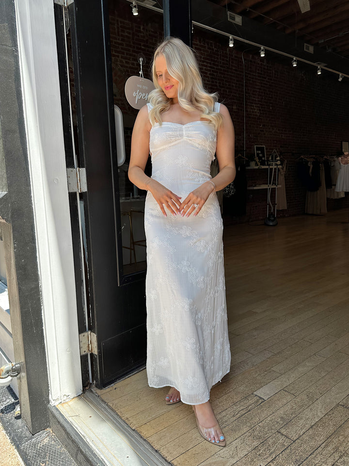 Woman white maxi dress with embroidery detailing and open tie back. 
