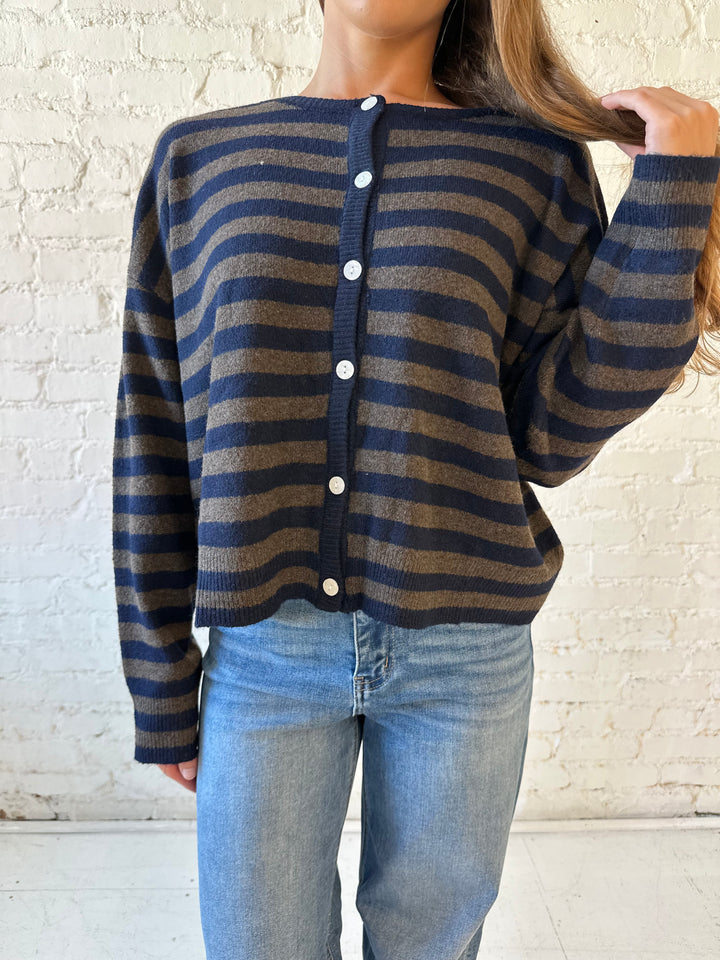 Woman wearing navy and taupe striped button down cardigan with medium wash jeans.