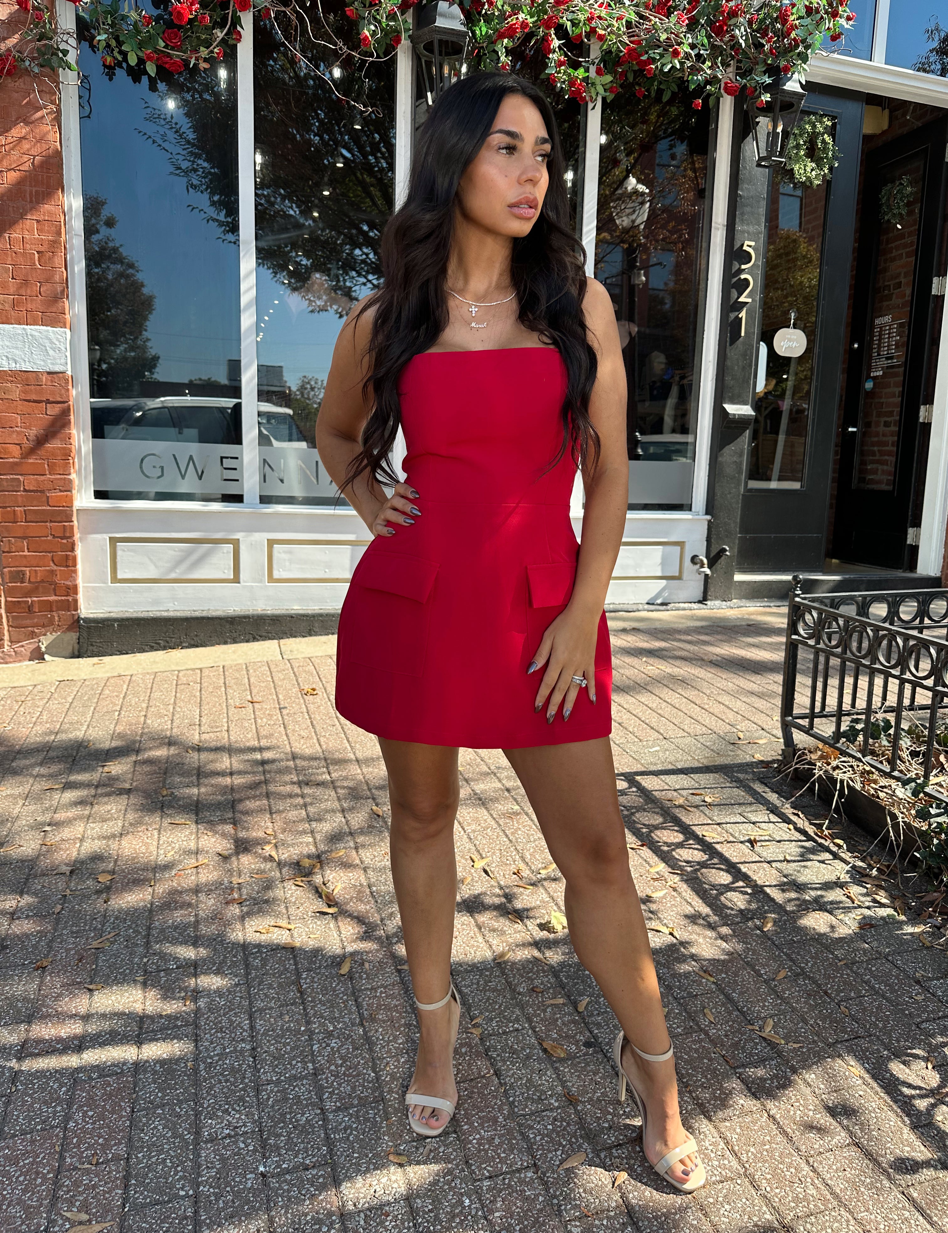 Woman wearing red strapless tailored mini dress with built in shorts. 