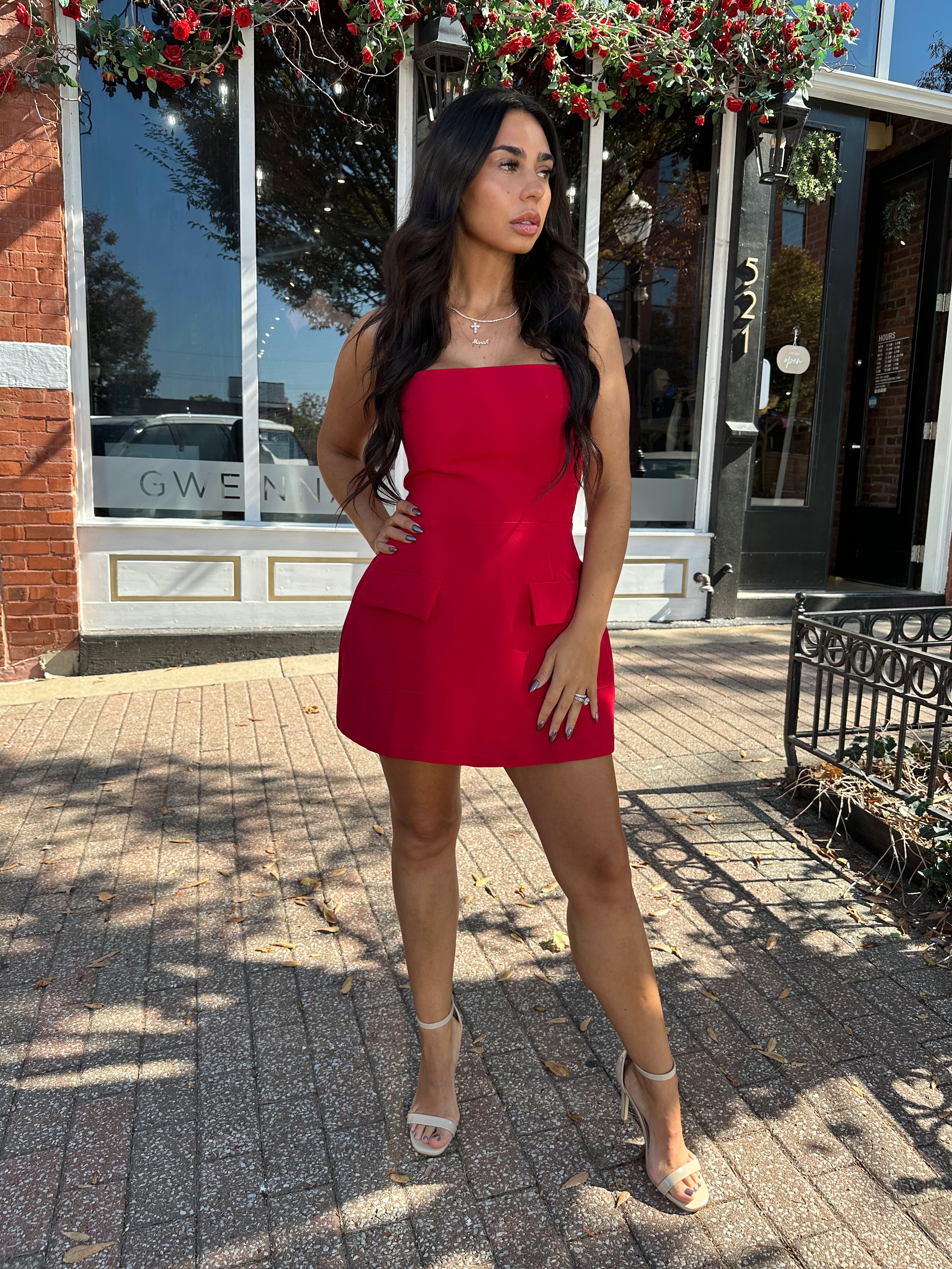 Woman wearing red strapless tailored mini dress with built in shorts. 