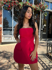 Woman wearing red strapless tailored mini dress with built in shorts. 