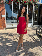 Woman wearing red strapless tailored mini dress with built in shorts. 