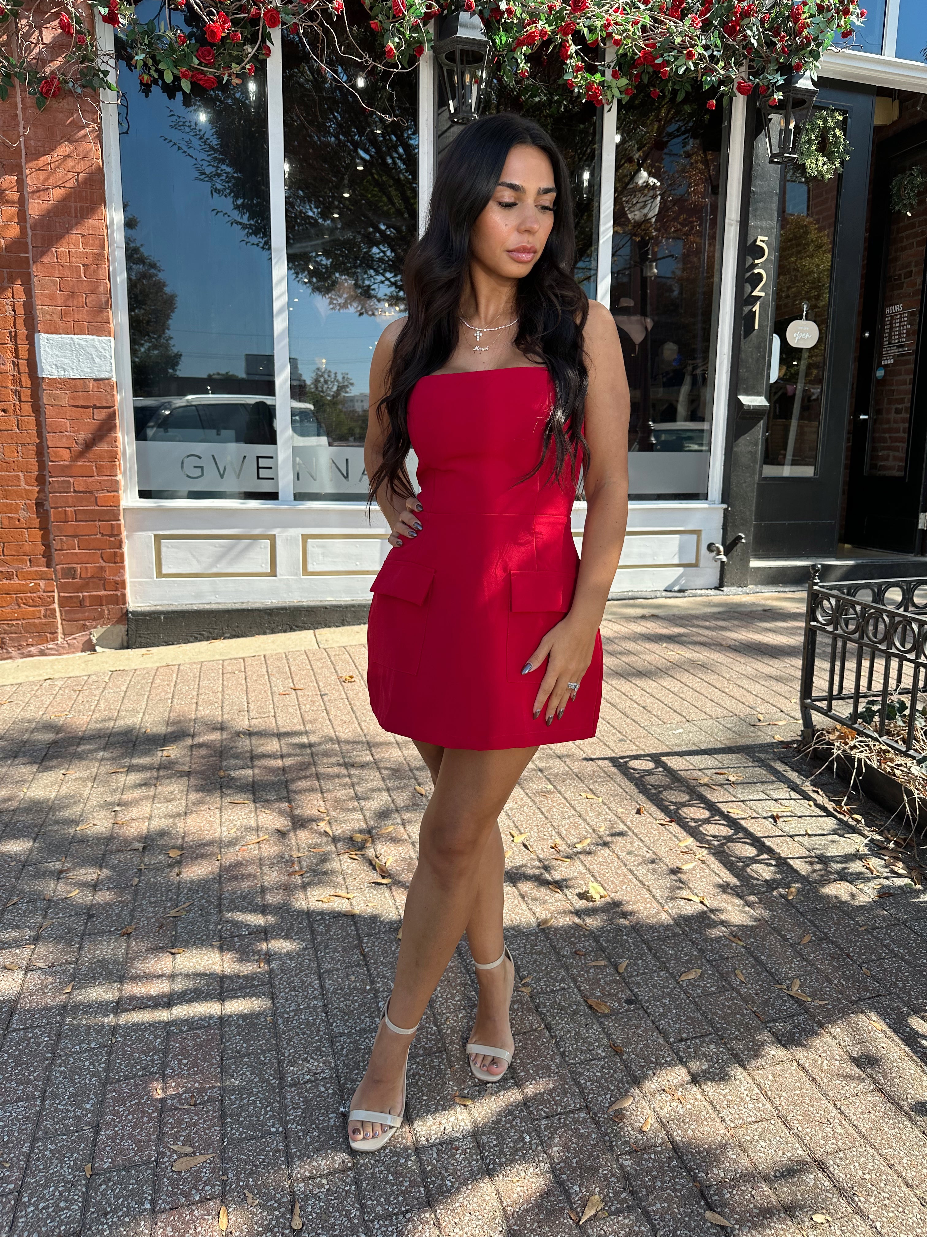 Woman wearing red strapless tailored mini dress with built in shorts. 
