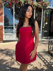 Woman wearing red strapless tailored mini dress with built in shorts. 