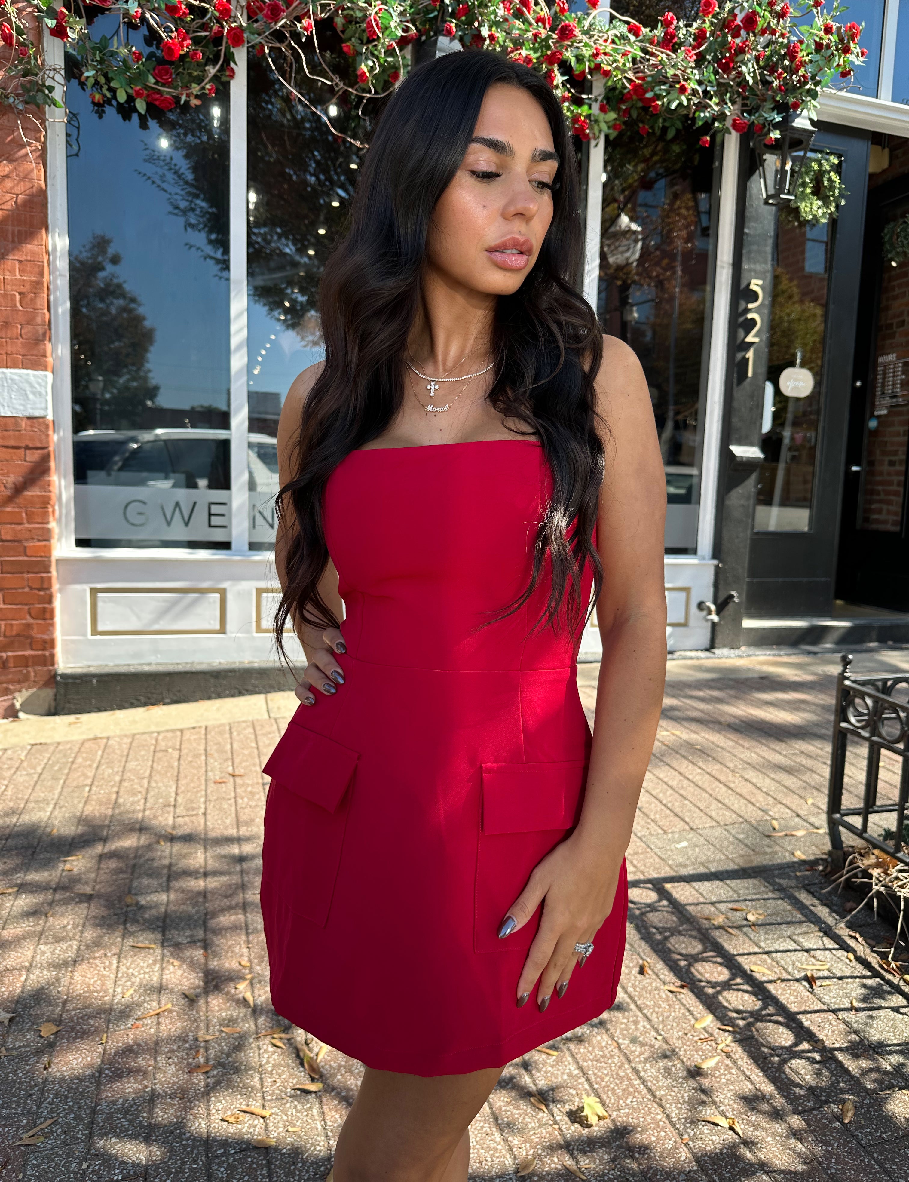 Woman wearing red strapless tailored mini dress with built in shorts. 