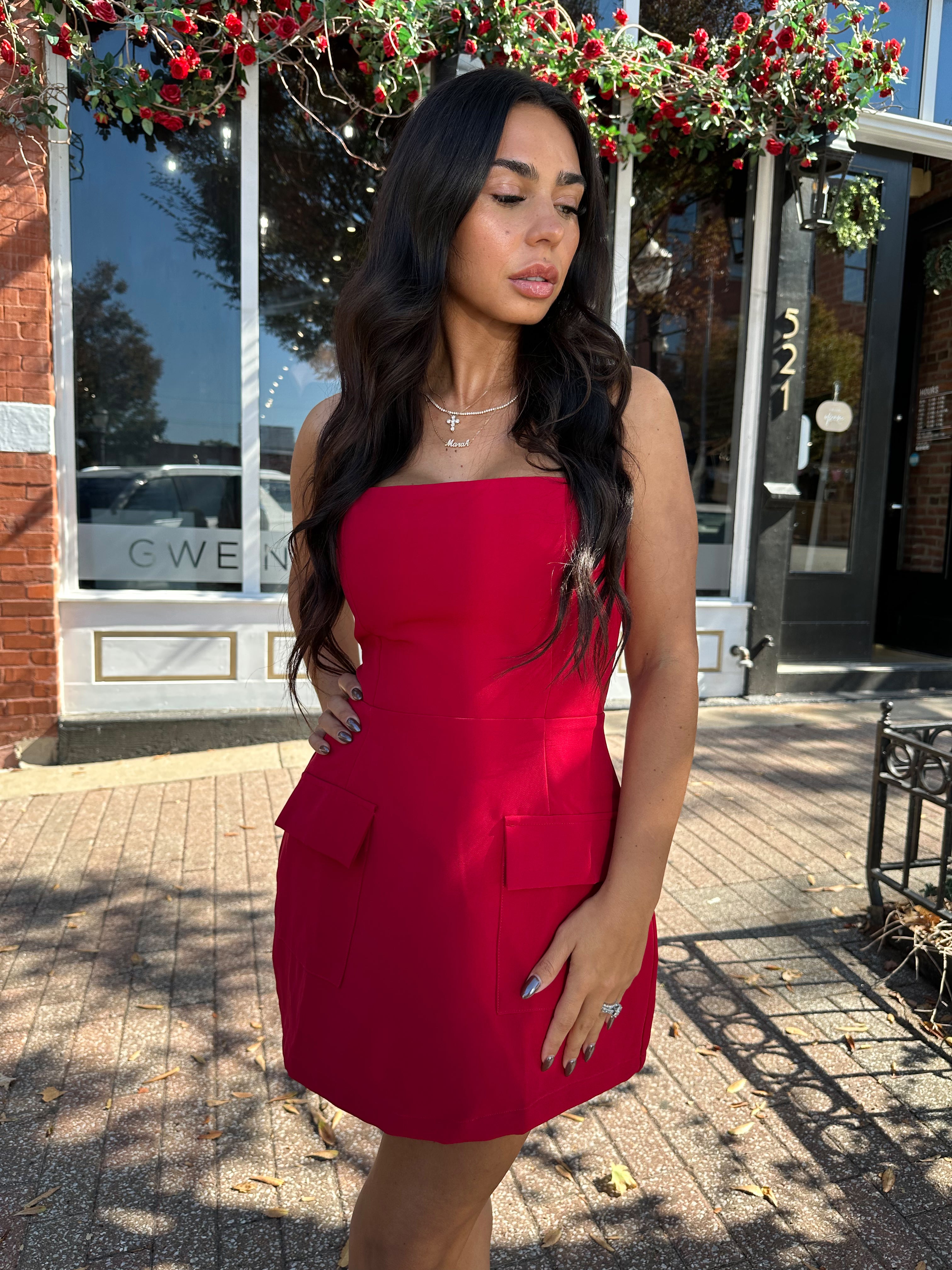 Woman wearing red strapless tailored mini dress with built in shorts. 