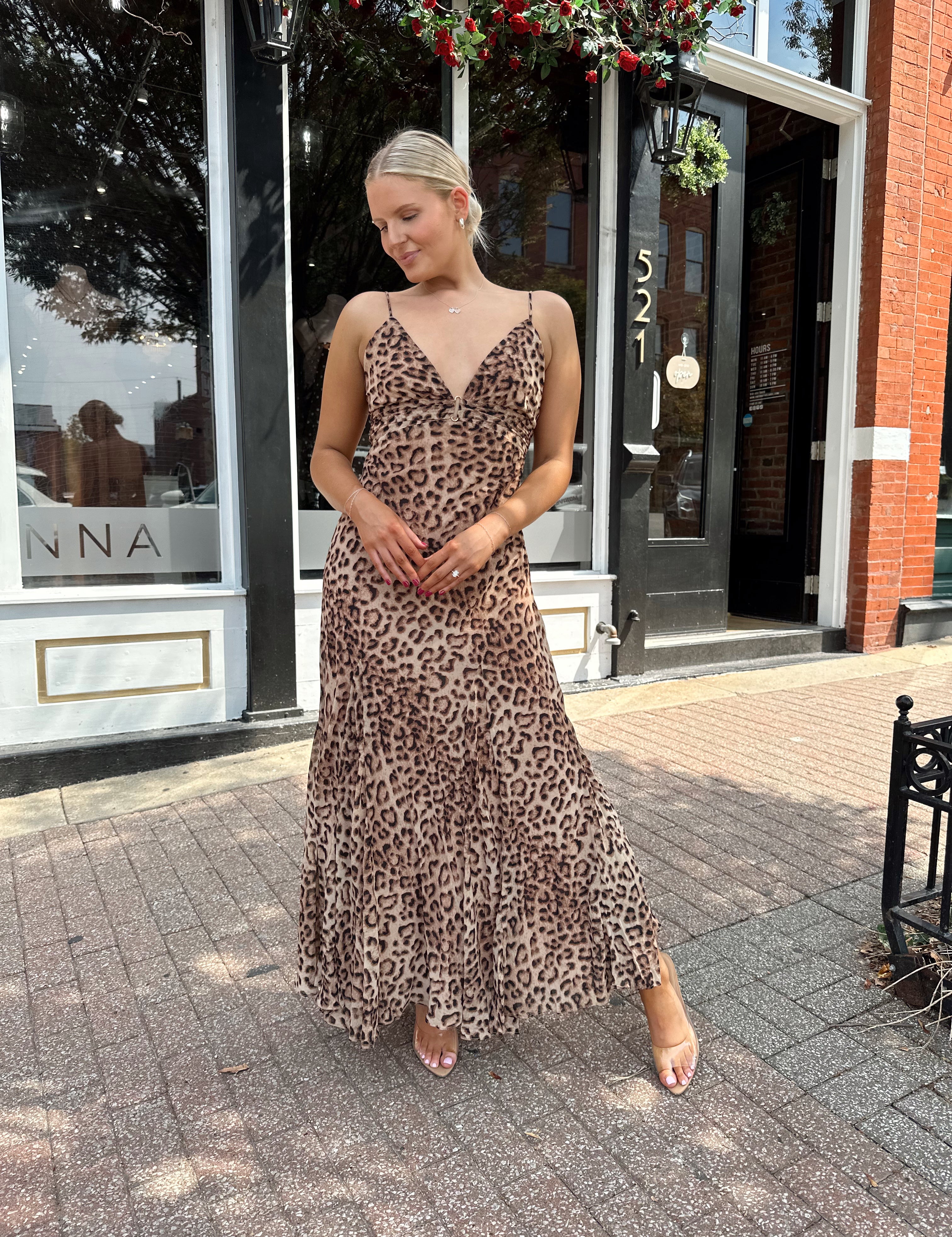 Woman wearing leopard maxi dress with v-neckline and adjustable straps.