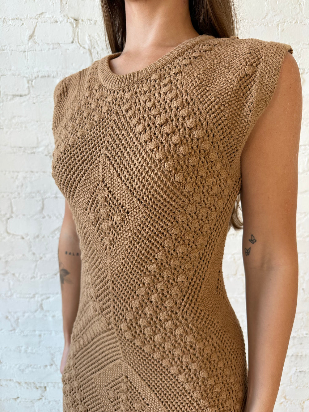 Woman wearing brown textured midi dress with side slits.