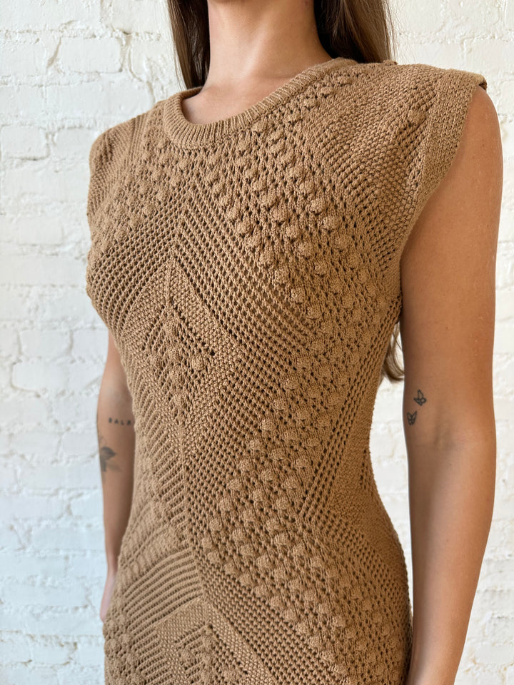 Woman wearing brown textured midi dress with side slits.