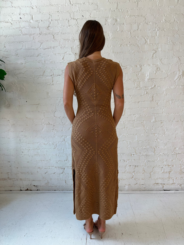 Woman wearing brown textured midi dress with side slits.