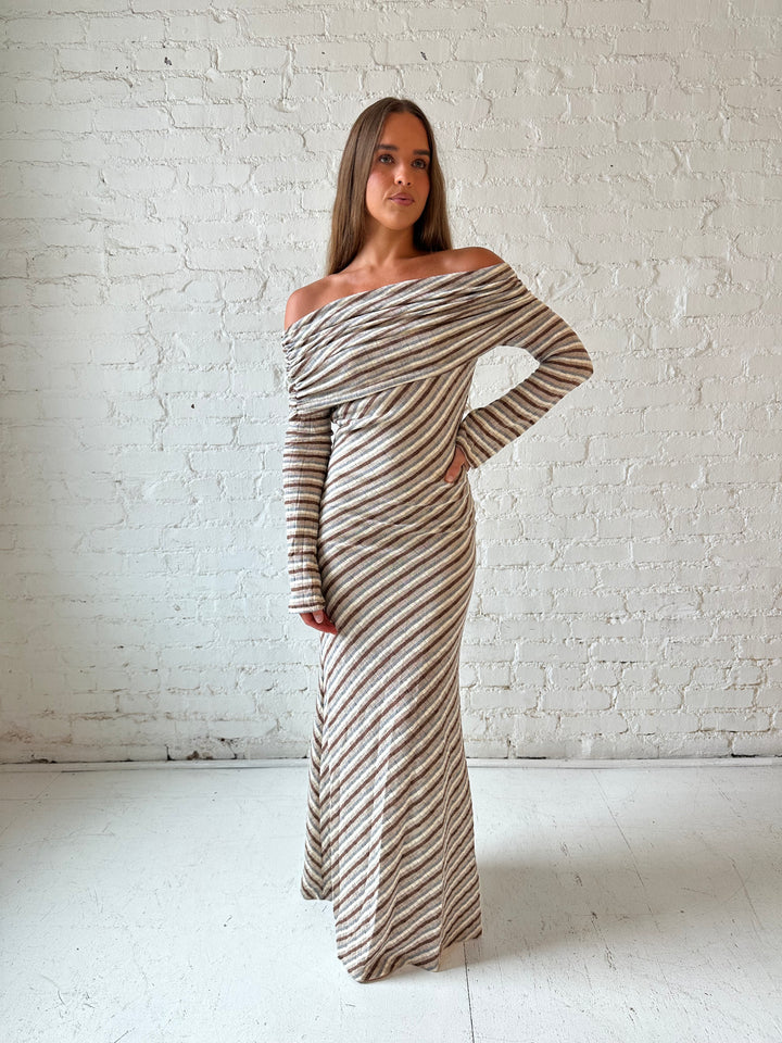 Woman wearing neutral striped fold over knit maxi dress with long sleeves.
