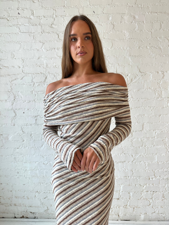 Woman wearing neutral striped fold over knit maxi dress with long sleeves.