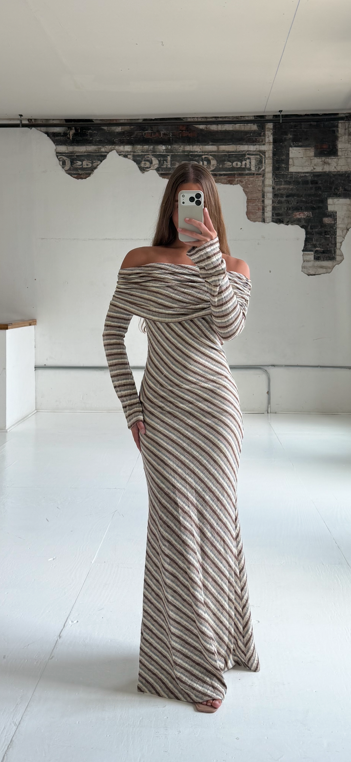 Woman wearing neutral striped fold over knit maxi dress with long sleeves.