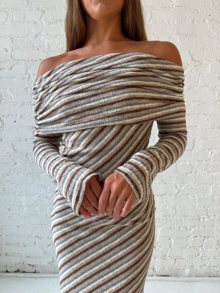 Woman wearing neutral striped fold over knit maxi dress with long sleeves.