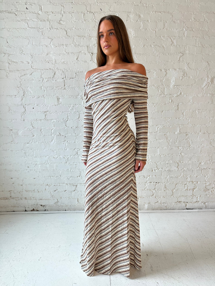 Woman wearing neutral striped fold over knit maxi dress with long sleeves.