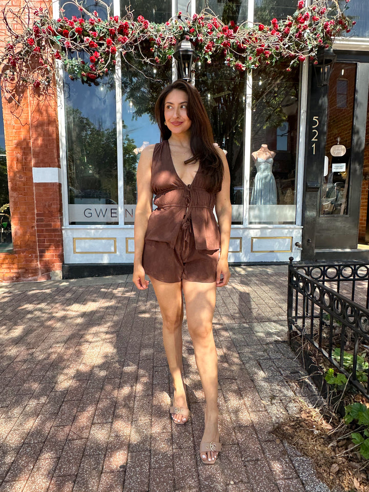 Woman wearing chocolate brown two piece set with front tie top, and shorts.  