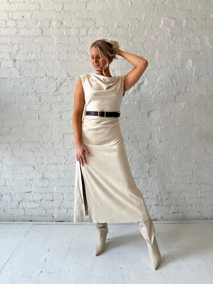 Woman wearing beige suede midi dress with belted waist and side slit. 
