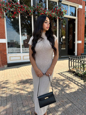 Woman wearing fitted taupe knit midi dress with short sleeves. 