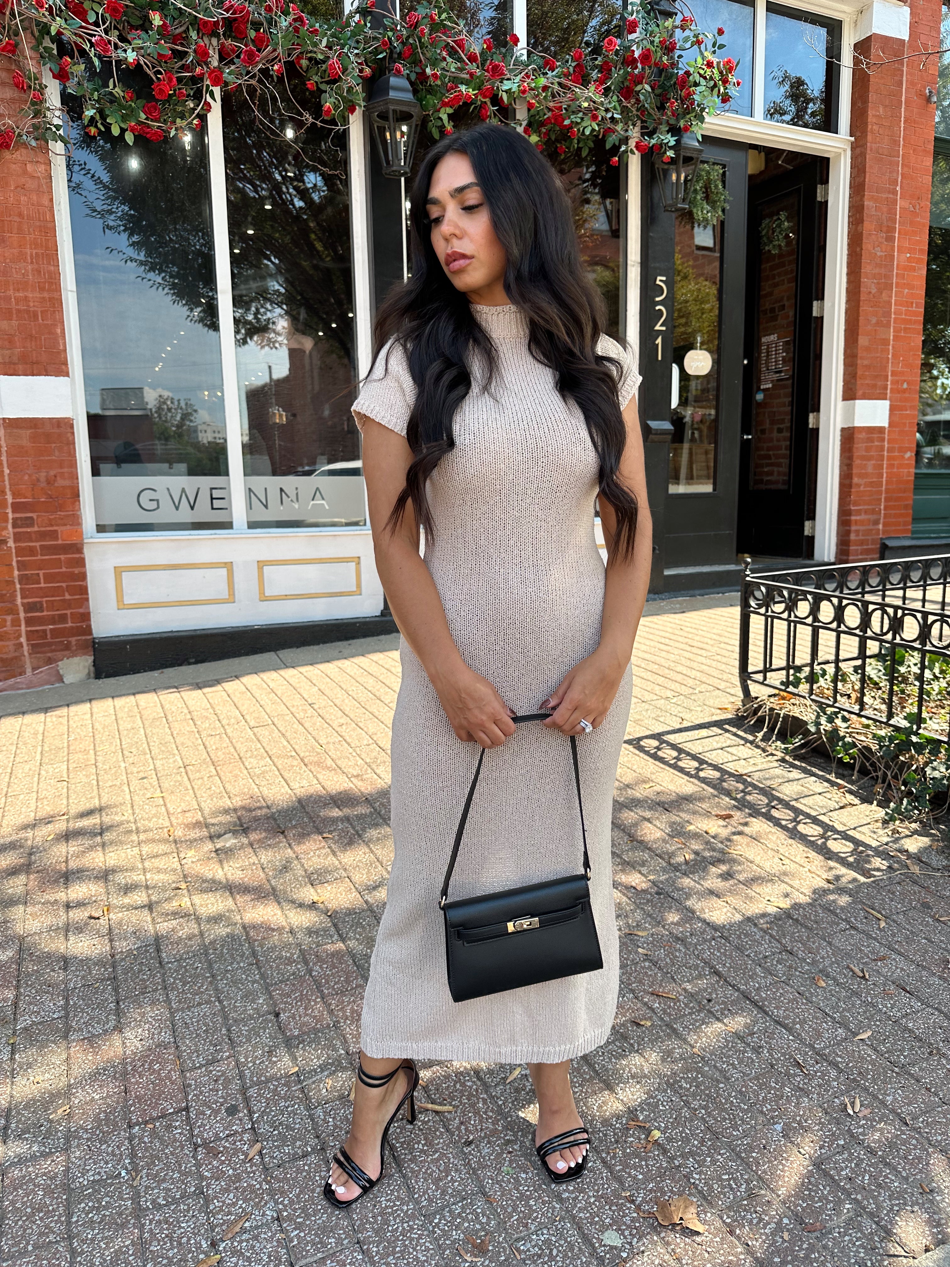 Woman wearing fitted taupe knit midi dress with short sleeves. 