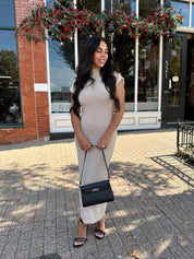 Woman wearing fitted taupe knit midi dress with short sleeves. 