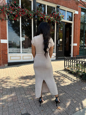 Woman wearing fitted taupe knit midi dress with short sleeves. 