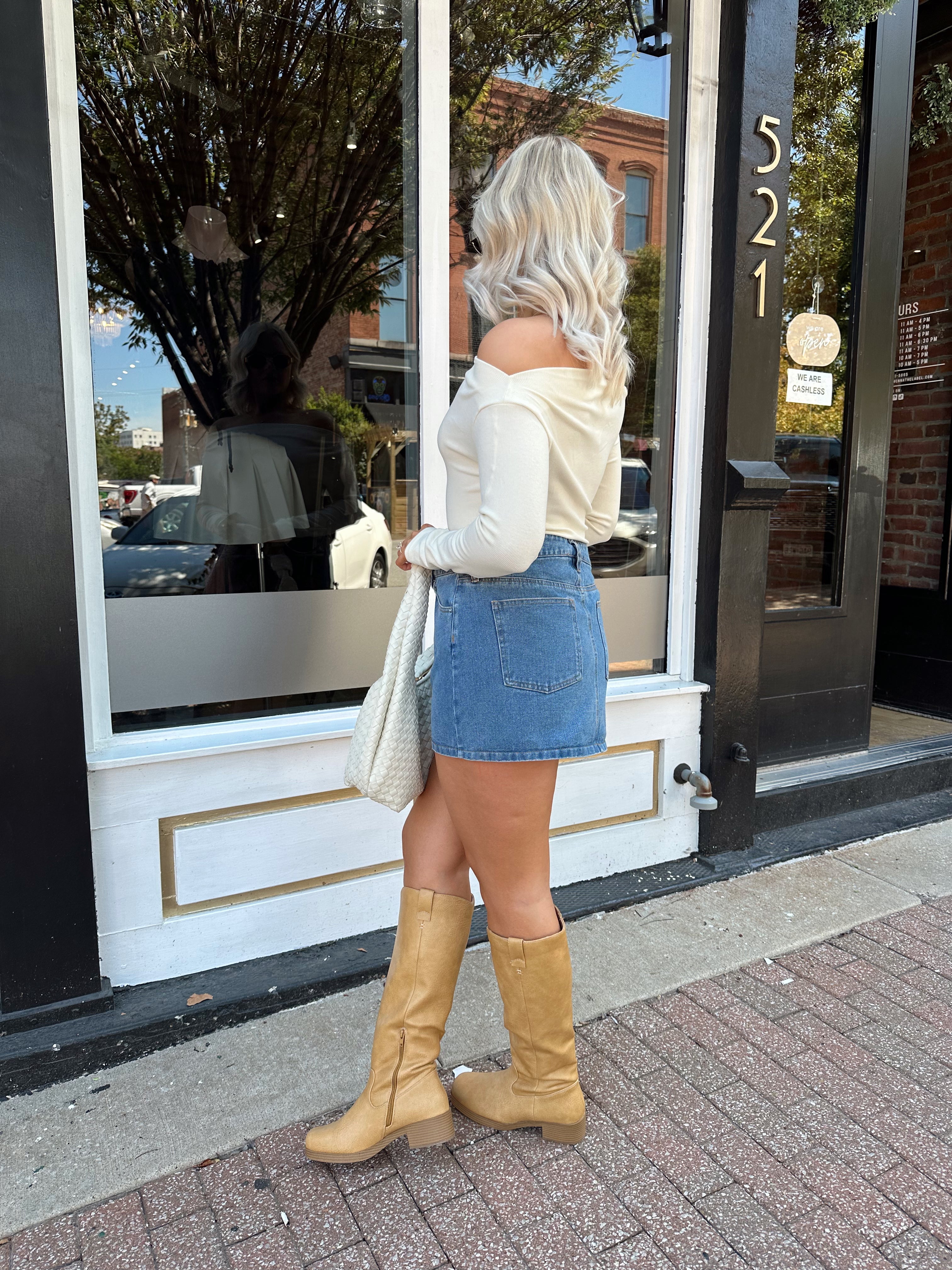 Woman wearing ribbed long sleeve off the shoulder bodysuit. 