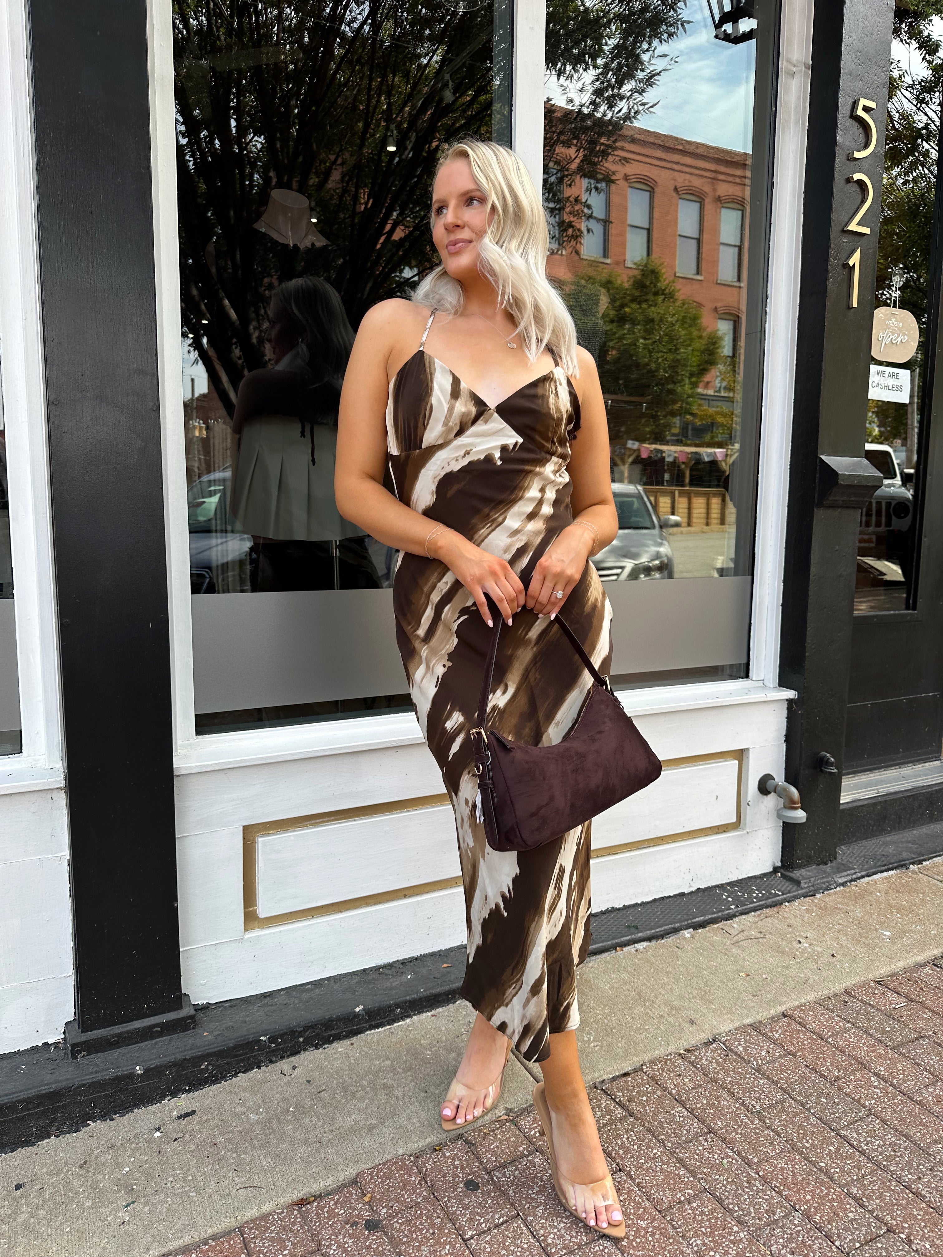 Woman wearing brown abstract pattern midi dress with cross cross back.