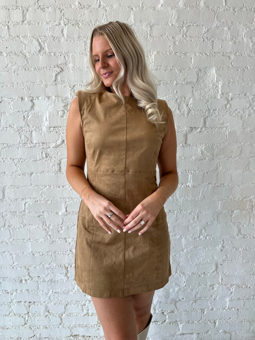 Woman wearing tan suede a-line mini dress with cream knee boots.