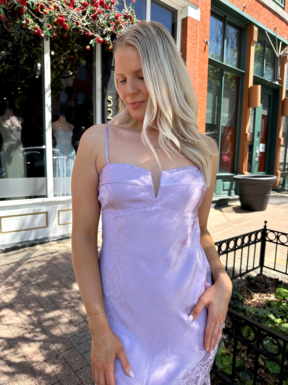Woman wearing purple jacquard maxi dress with adjustable spaghetti straps.