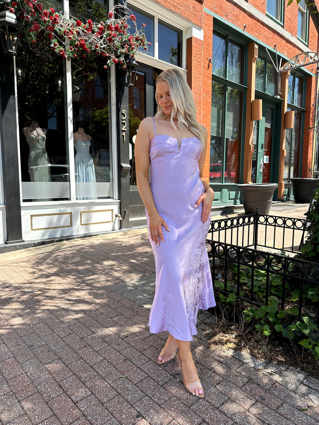 Woman wearing purple jacquard maxi dress with adjustable spaghetti straps.