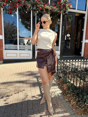 Woman wearing burgundy leather mini wrap skort. 