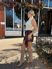Woman wearing burgundy leather mini wrap skort. 