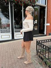 Cream colored ribbed long sleeve off the shoulder bodysuit. 
