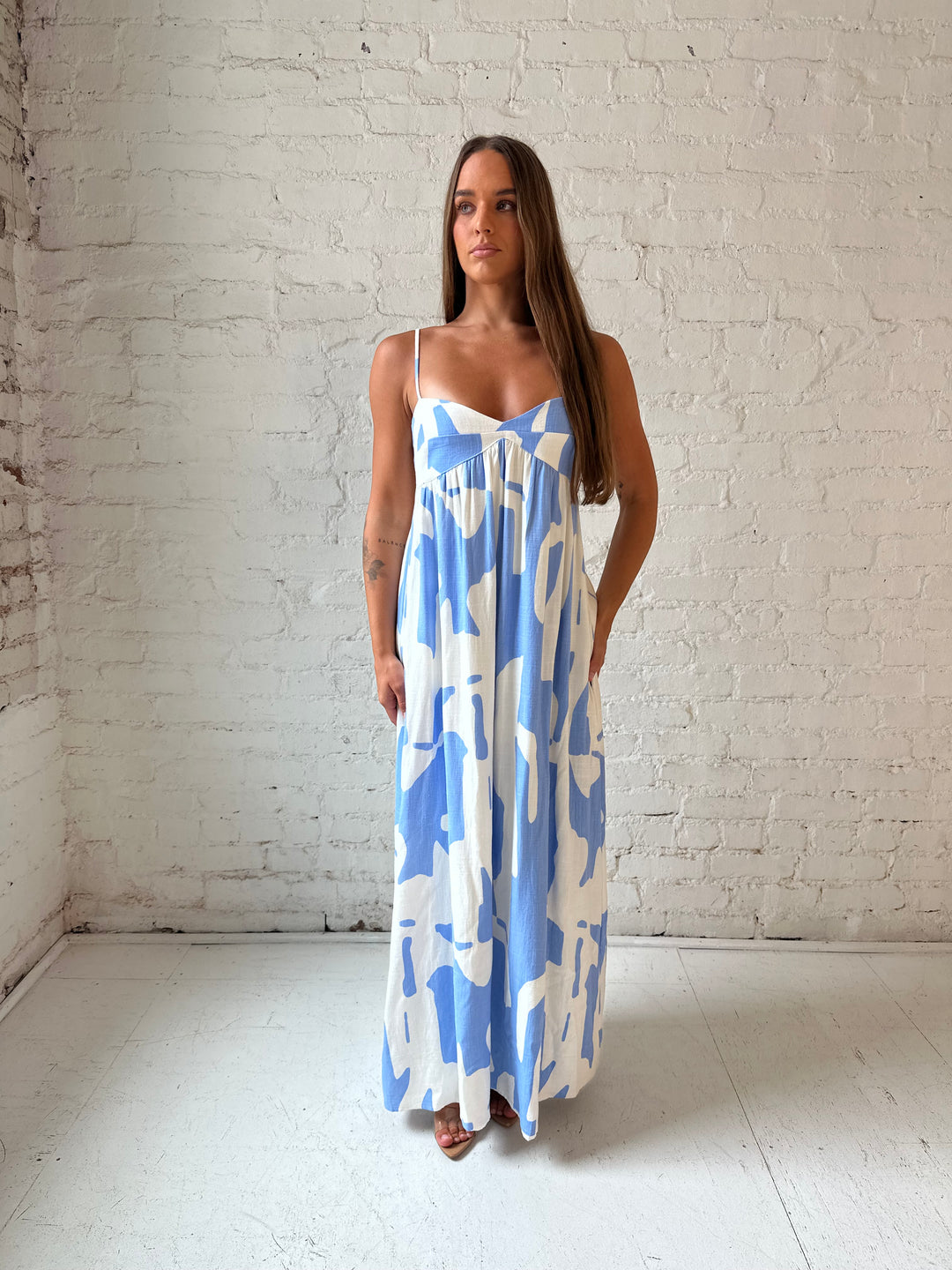 Woman wearing blue and white geometric print maxi dress with sweetheart neckline.