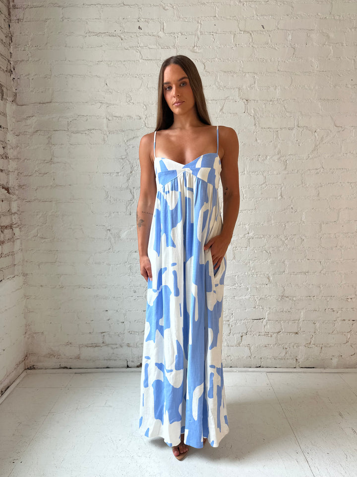 Woman wearing blue and white geometric print maxi dress with sweetheart neckline.