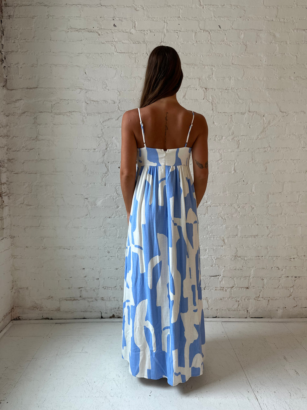 Woman wearing blue and white geometric print maxi dress with sweetheart neckline.