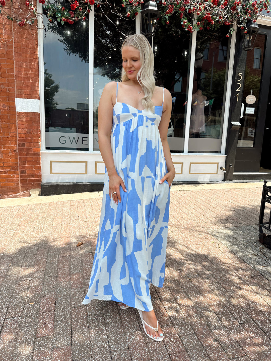 Woman wearing blue and white abstract pattern maxi dress with sweetheart neckline. 