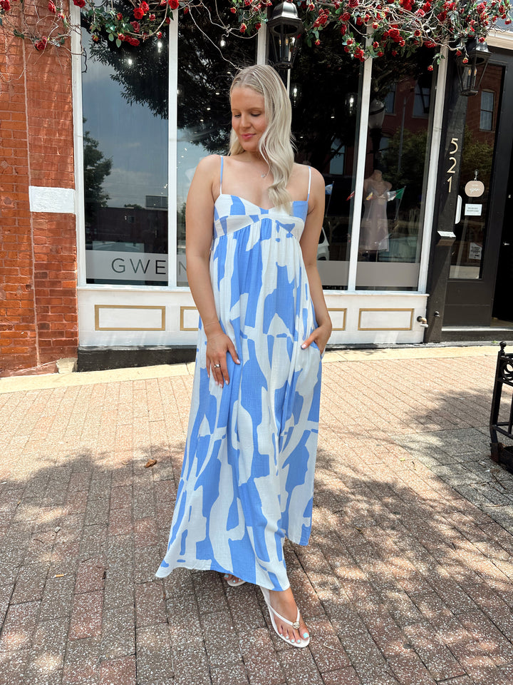 Woman wearing blue and white abstract pattern maxi dress with sweetheart neckline. 