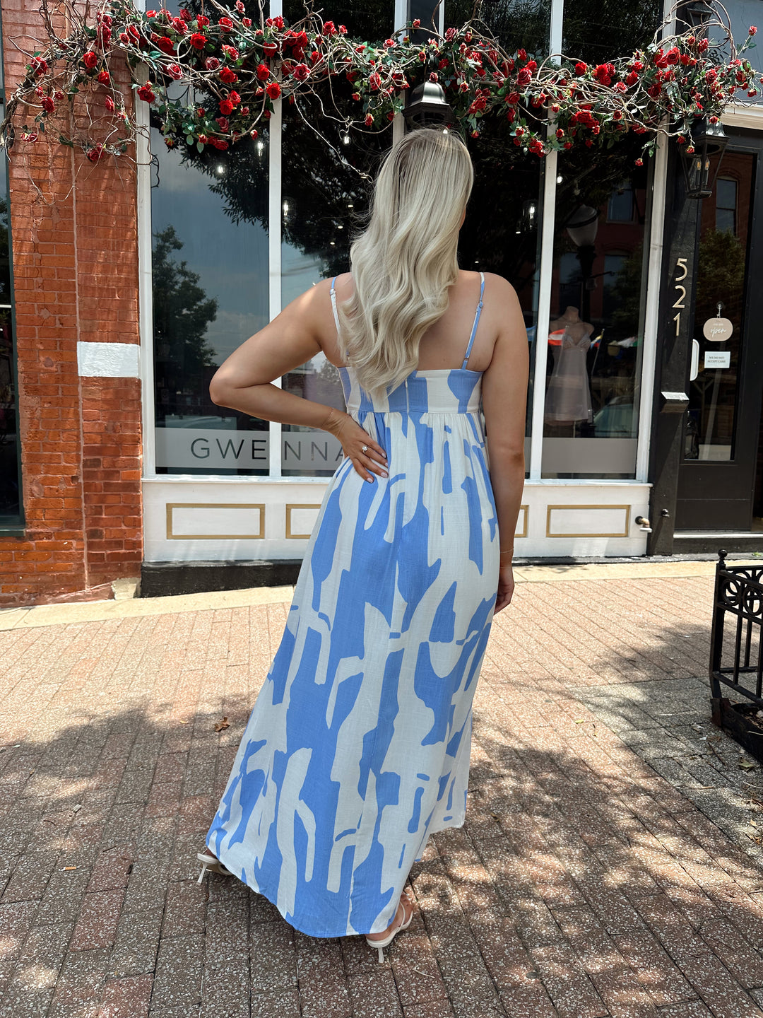 Woman wearing blue and white abstract pattern maxi dress with sweetheart neckline. 